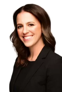 
Professional headshot of a smiling Cristina Di Maria with shoulder-length brown hair, wearing a black blazer against a white background.