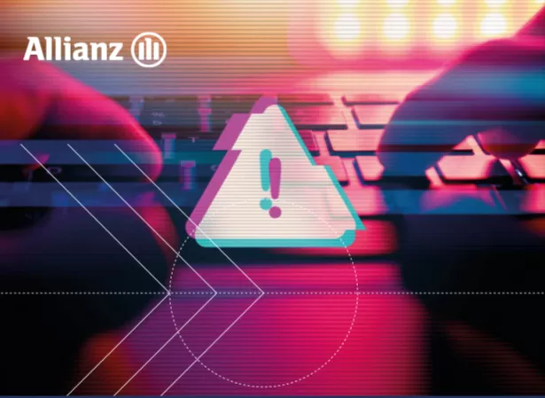 The cover of the report shows the Allianz logo in the top left corner, with a stylized warning triangle containing an exclamation mark at the center. The background features a close-up of hands typing on a keyboard, overlaid with digital glitch effects in vibrant pink, blue, and purple tones, evoking a sense of cybersecurity and digital risk. Geometric shapes and lines enhance the futuristic theme.