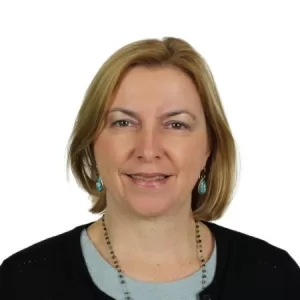 Headshot of Siobhan O'Brien, a professional with blonde hair, wearing a black sweater, light top, and turquoise earrings, smiling warmly.