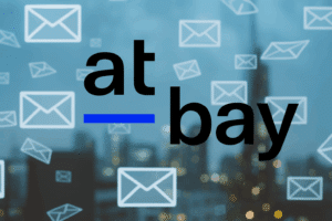 At-Bay logo over a digital cityscape with email icons flying through the air, representing ransomware risks, remote access vulnerabilities, and ransomware cyber insurance trends from the 2025 InsurSec Report.
