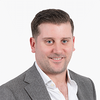 Headshot of Simon Hughes wearing a gray blazer and white shirt against a white background. Cowbell Cyber insurance provider has appointed Simon Hughes as Chief Commercial Officer